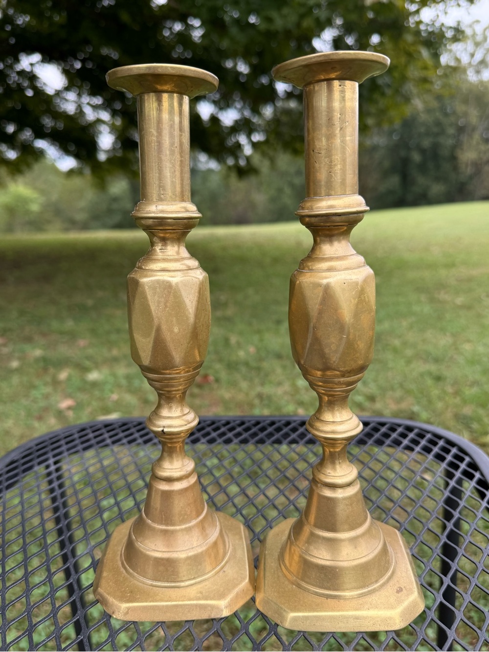 pair of antique English brass candlesticks with a distinctive geometric pattern